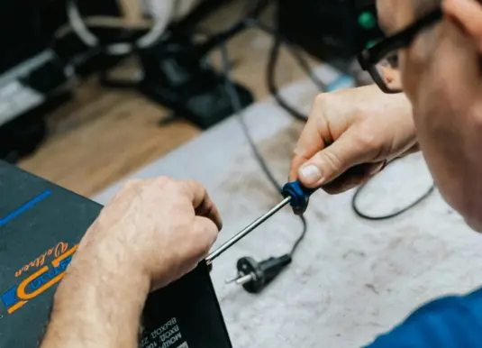 Tecnico che esegue test elettronici su una centralina auto in laboratorio