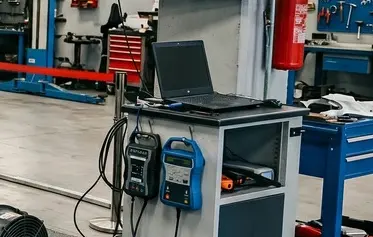Postazione tecnica con laptop e strumenti di diagnosi elettronica professionale per test a banco su componenti automotive in Italia.